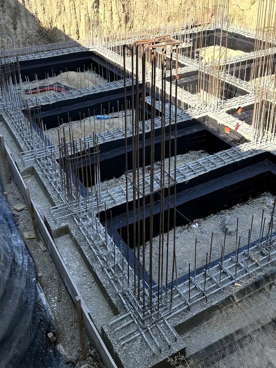 Grinzi de fundație turnate și hidroizolate pe exterior, cu armătura pregătită pentru elevații