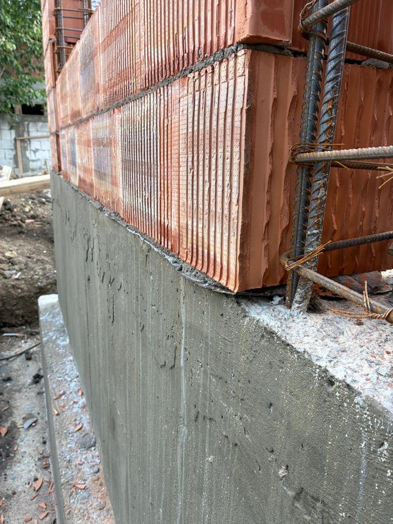 Detaliu cu zidăria, stâlpișorul armat și soclul de beton